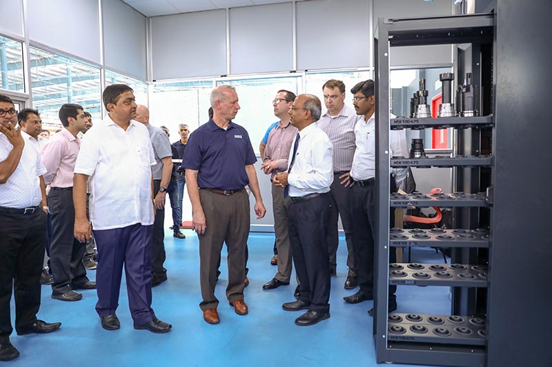 Die Teilnehmer stehen im Einstellraum. Rechts ist das Werkzeugausgabesystem zu sehen.