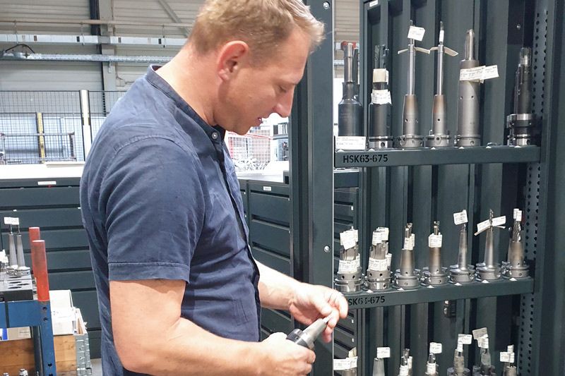 Matthias Hahn von MAPAL vor einem Vertikalschrank des UNIBASE Ausgabesystems.