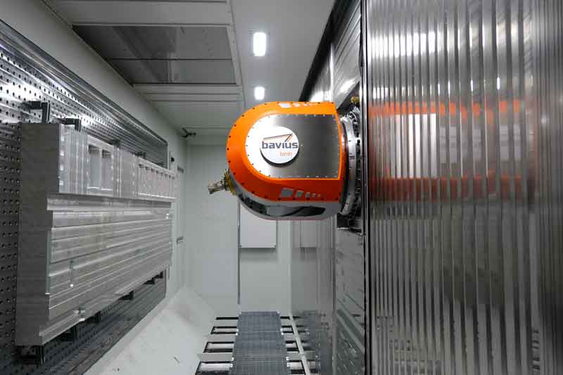 The picture shows the interior of the bavius machine with a large aluminum plate and the clamped OptiMill-Alu-Wave milling cutter.