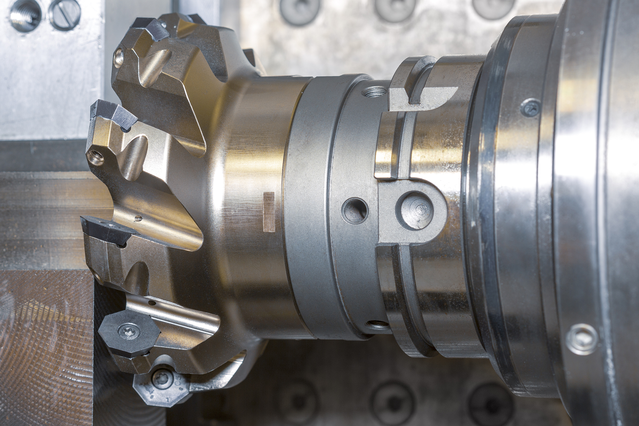 A milling cutter with radial indexable inserts in use in the machine.