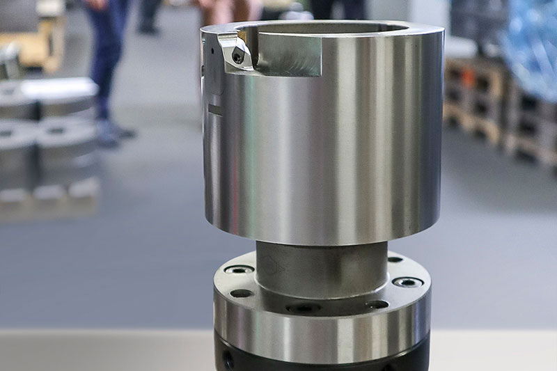 Im Vordergrund steht eine Außenreibahle mit Modul- und HSK-Schnittstelle. Im Hintergrund ist die Fertigung bei Völlm.